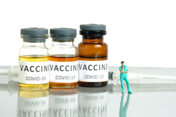 Miniature people toy figure photography. Vaccine injection concept. A nurse standing in front of...