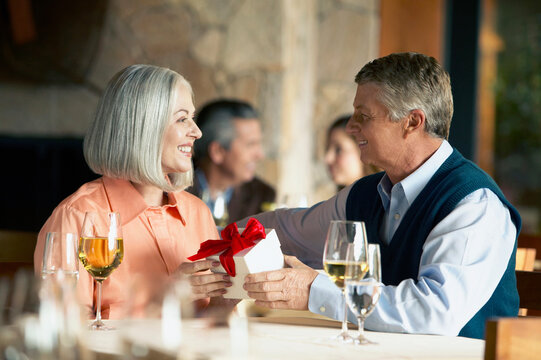 Mature Couple At Dinner With Gift