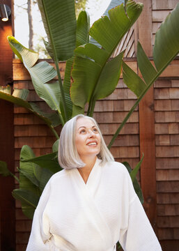 Smiling mature woman in bathrobe at spa