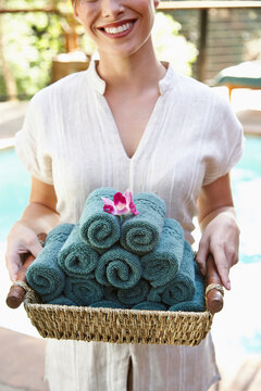 Spa therapist holding basket of hand towels