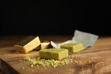 Bouillon cubes and crumbles on wooden board, closeup