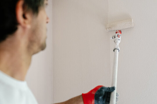 Unrecognizable bricklayer painting a wall