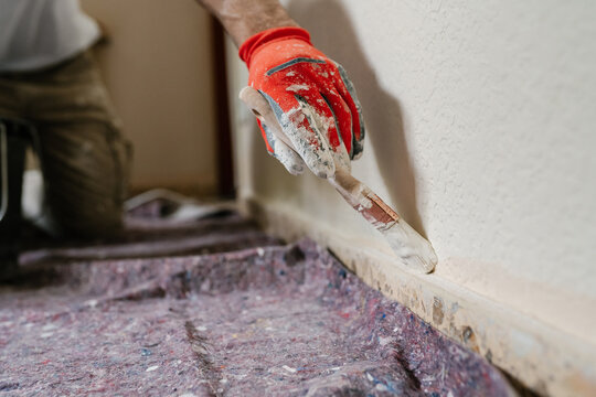 Anonymous hand of construction worker painting a wall.
