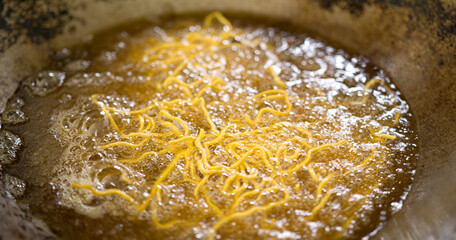 Noodles in a pan with boiling oil Many bubbles pops up due to the high heat produced by the stove..