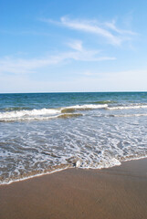 Blue skies with a calm surf