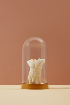 Candle with male shape on brown background
