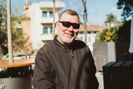 A middle-aged man smiling and walking