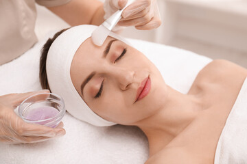 Obraz na płótnie Canvas Young woman during face peeling procedure in salon
