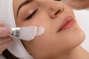 Young woman during face peeling procedure in salon, closeup
