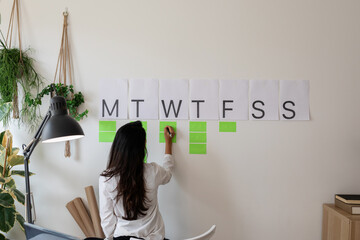  writing notes in a weekly wall organizer 