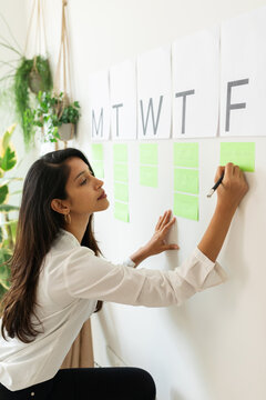  Woman Writing In A Weekly Wall Organizer 