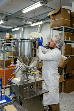 Factory Worker Pouring Liquid In Tank