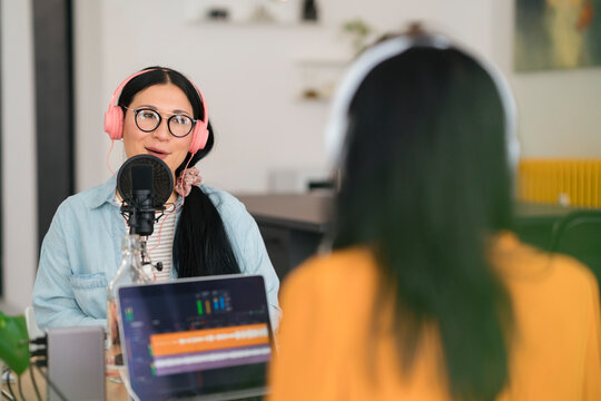 Women recording podcast in modern studio together