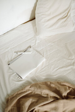 Notebook with a pen on the bed
