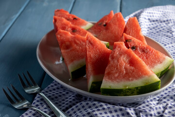 Sliced watermelon. Slices on rustic blue table. Copy space.