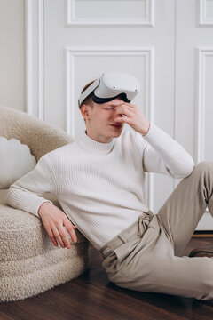 Tired man with VR headset rubbing eyes