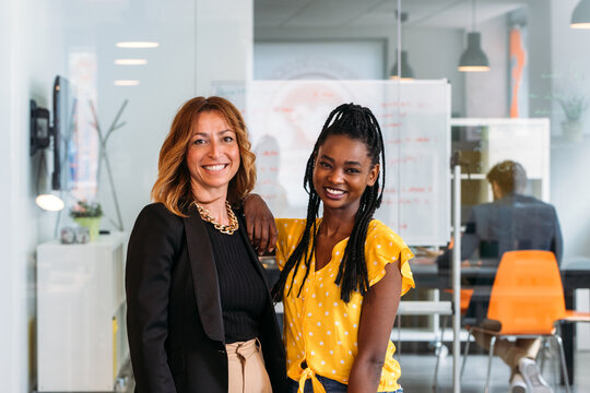 Happy multiethnic colleagues posing in modern office