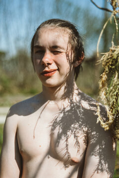 Topless teen in a tree shadow