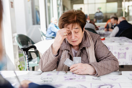 Senior woman concentrated playing cards