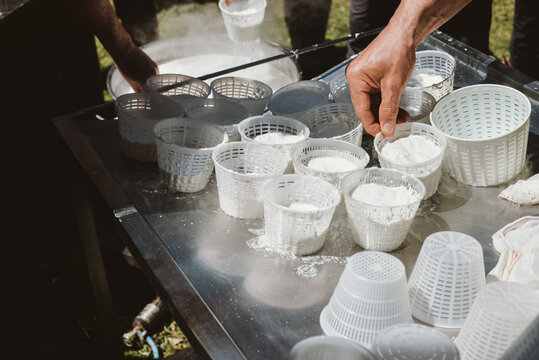 Man's hands making fresh ricotta cheese 
