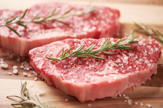 Two Raw Sirloin Strip Steaks On Cutting Board 