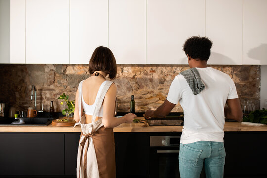 Young couple from back cooking at modern kitchen