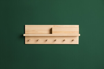 Wooden hanger for keys on green wall