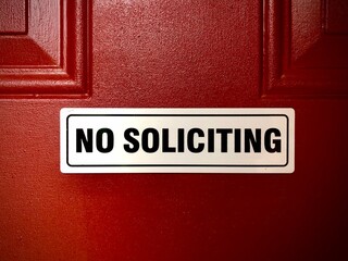 No soliciting sign on a red door