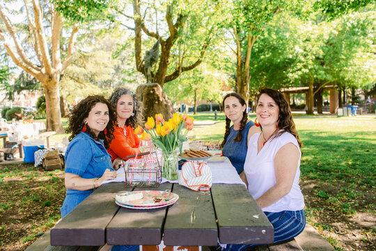 Women at a table with flowers  in town square 