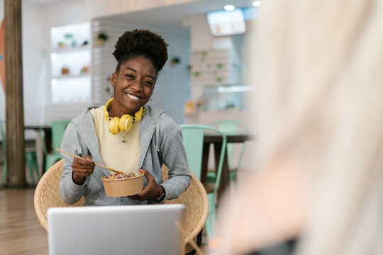 Happy black afro woman eating healthy