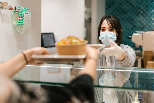 Employee of a health food restaurant serving a customer