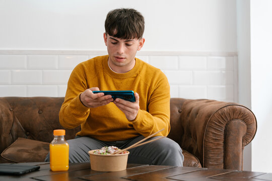 Man taking photo of poke for social media during lunch