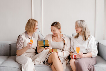 Woman giving present for friend during birthday celebration at home