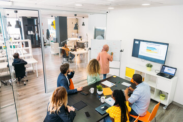 Crop multiethnic coworkers talking at office table