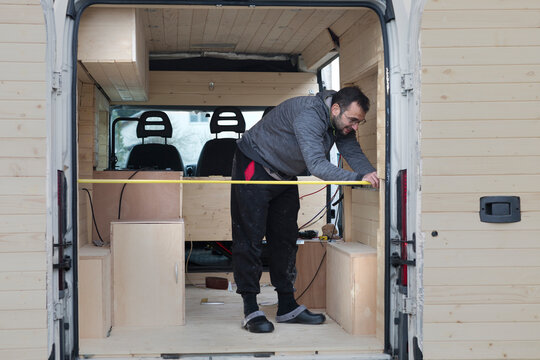 Men Setting Up Bed in Camper Van
