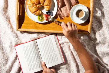 person reading a book at breakfast