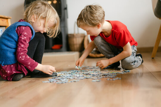 boy and girl solving a jigsaw puzzle 
