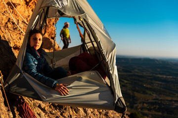Climbers resting inside a wall portaledge in height