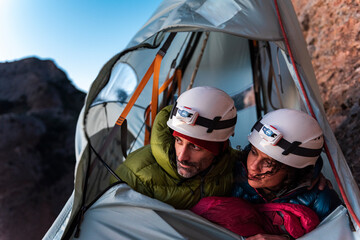 Climbers with safety helmets inside a wall tent