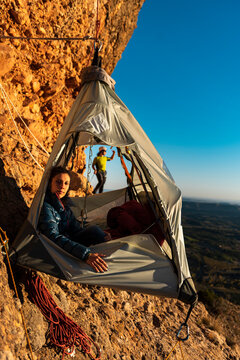 Climbers resting inside a wall portaledge in height