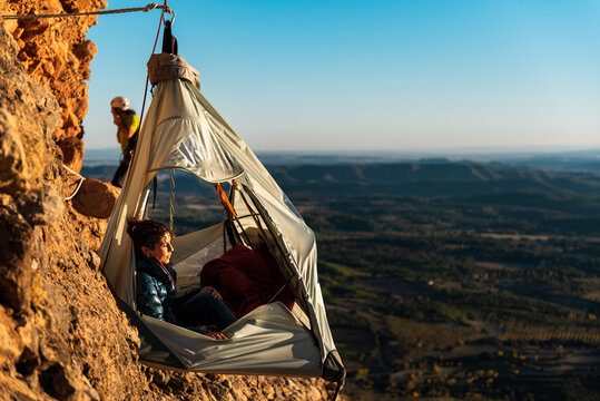 Climbers resting inside a wall portaledge at mountain