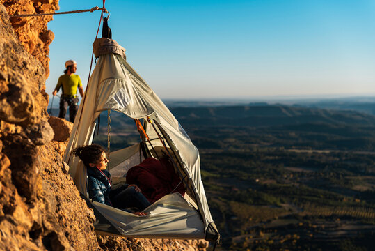 Climbers resting inside a wall portaledge at mountain