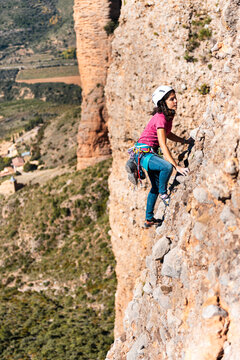 Young woman climbing a multipitch route outdoor
