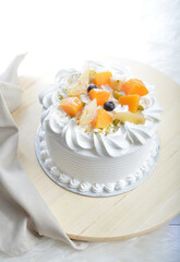 vanilla ice cream birthday butter cream cake with fresh mixed fruits peach, berry, mango on top in white background pastry halal menu