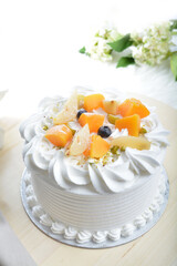 vanilla ice cream birthday butter cream cake with fresh mixed fruits peach, berry, mango on top in white background pastry halal menu