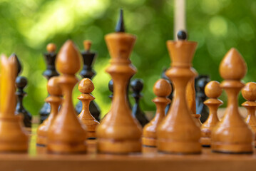 Chess pieces of shabby old chess pieces on a chessboard close up - white pawn in selective focus