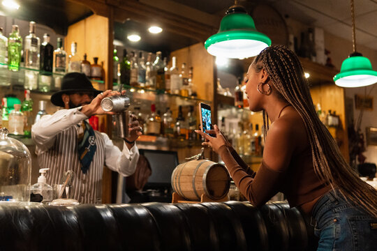 Black woman shooting mixologist in bar