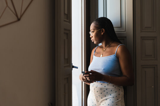 Relaxed Black Woman Looking Away In Window