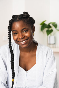 Delighted black woman looking at camera at home