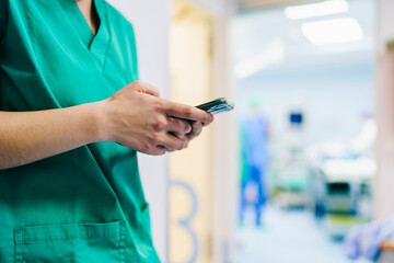 The hands of a doctor with a phone in the hospital